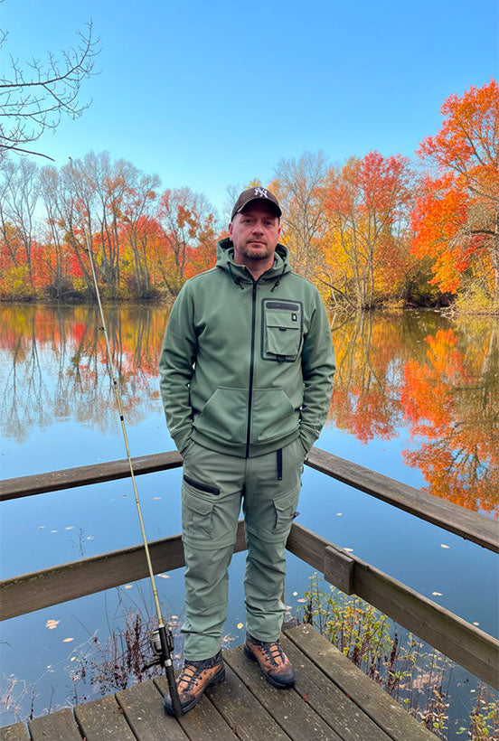 Founder Pierre-Yves standing with his fishing rod on a pier, dressed in the Elyzion collection